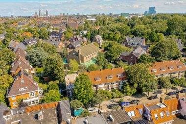 Şehir yukarıdan, birçok ev ve ağaçla dolu. Görüntü bir hava aracı kamerasından alındı.