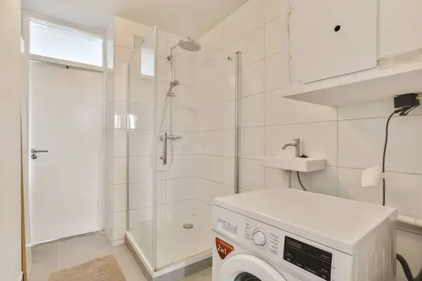 a laundry room with a washer, dryer and washing machine in the corner next to the shower stall