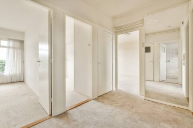 Duvarında beyaz duvarlar ve aynalar olan boş bir oda. Görünürde kimse yok.