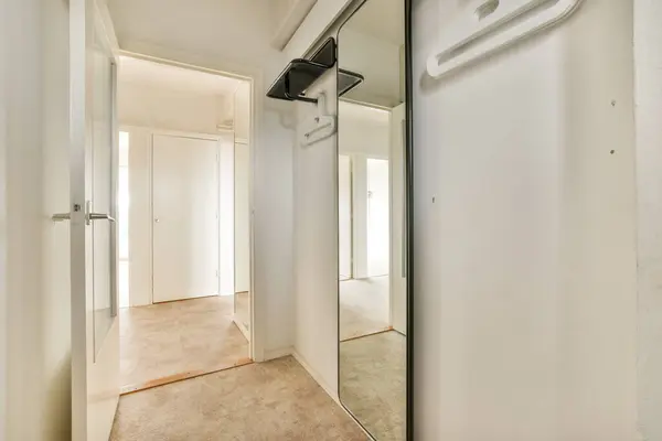 an empty room with a mirror hanging on the wall and two closet doors open to reveal a walk - in closet