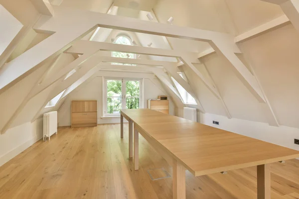 a kitchen and dining area in an attic style home with white walls, wood flooring and vaulteded ceiling