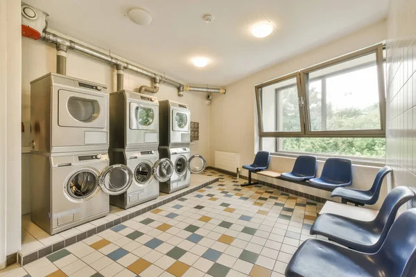 a laundry room with washer and dryer in the corner next to an open door that leads to a large window