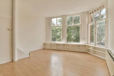 Ağaç döşemesi ve geniş pencereli boş bir oda bölgedeki ağaçlara bakmak çok temiz.