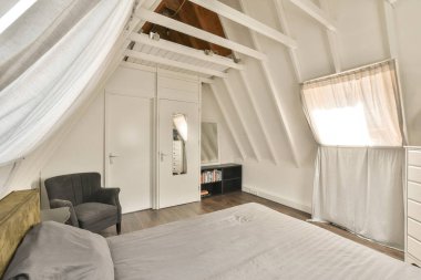 Tavan arasında yatak odası, sandalye ve pencere yıllardır kullanılmakta olan bir yatak odası.