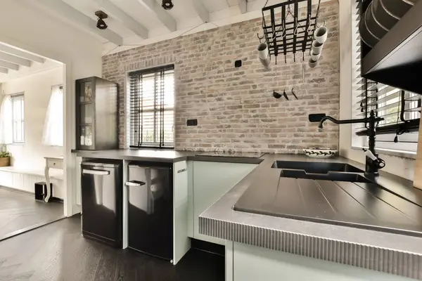 a kitchen with an oven and dishwasher in the middle part of the room there is a brick wall behind it