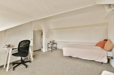 Yatak odası, masa ve bilgisayar. Pencerenin önünde. Dışarıya bakıyor.