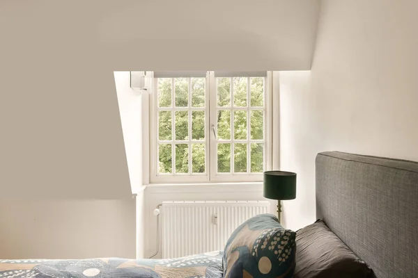 a bedroom with a bed, window and wallpaper on the walls that are painted in light grey color scheme