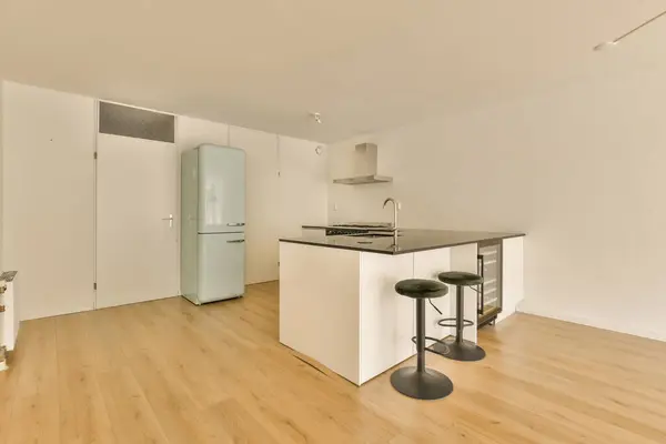 an empty kitchen and dining area in a new apartment with white walls, hardwood flooring and light wood floors