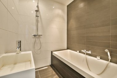 Fotoğrafta küveti, lavabosu ve tuvalet kağıdı tutacağı olan bir banyo yan taraftan sağdan çekiliyor.
