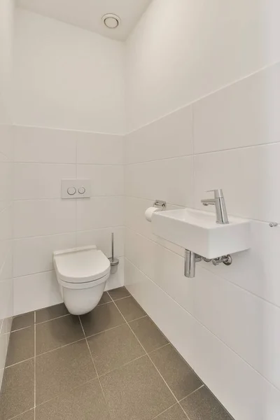 a bathroom with white walls and tile flooring the toilet is on the left side of the wall to the right