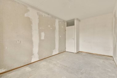 Duvarında beyaz duvarlar ve kuru alçı olan bitmemiş bir oda beton gibi görünmesi için kullanılıyor.