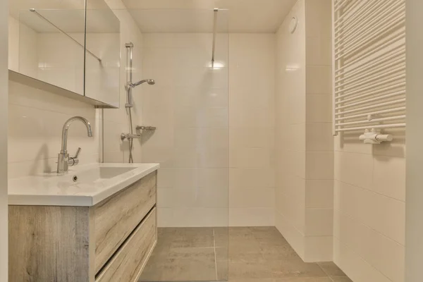 a bathroom with a sink, mirror and shower head mounted on the wall above the sink is a towel rack