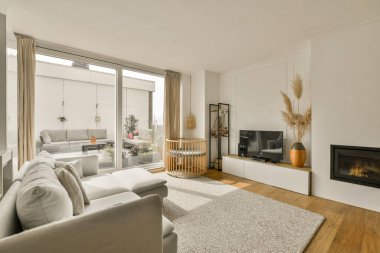 Oturma odası, kanepeler ve odanın ortasında dışarıya açık bir şömine.