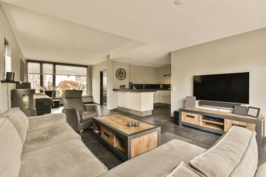 Oturma odası, kanepeler ve odanın duvarına monte edilmiş düz ekran bir televizyon çok modern.