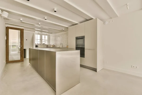 a kitchen area in an apartment with white walls and light wood trim on the countertop, along with stainless appliances