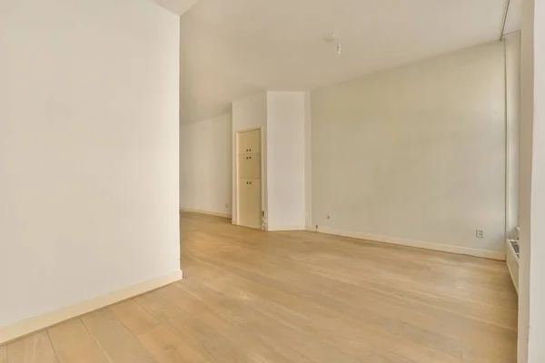 an empty room with white walls and wood flooring in the center of the room is a mirror on the wall