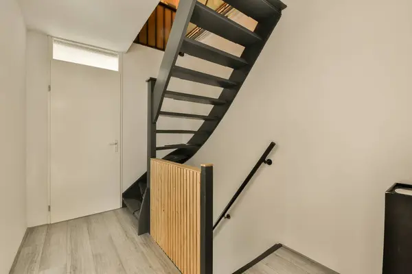 a room with stairs and an open space to the other rooms on the left, there is a tv in the corner