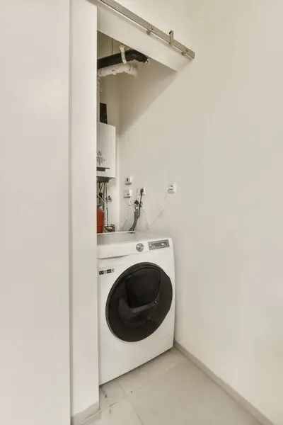 a small laundry room with a washer and dryer in the corner on the left side of the wall