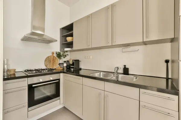 a kitchen area with white cabinets and black counter tops on the counters in this photo is taken from the inside