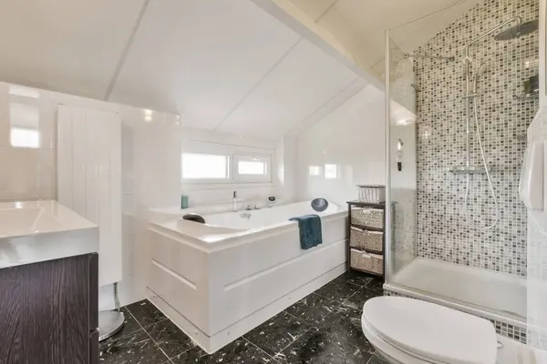 a modern bathroom with black and white mosaic tiles on the walls, along with a walk - in shower stall