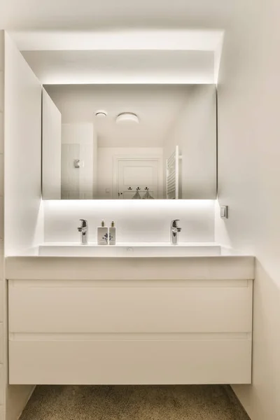 a bathroom with two sinks and mirrors on the wall above it is an illuminated mirror that reflects the light in the room
