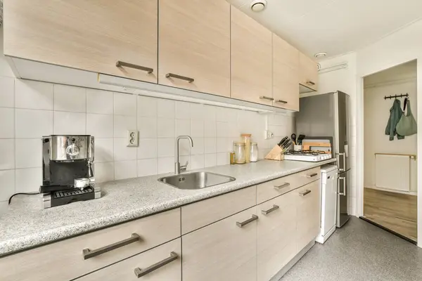 a kitchen area with white cabinets and counter space for the sink, coffee maker and toaster on the wall