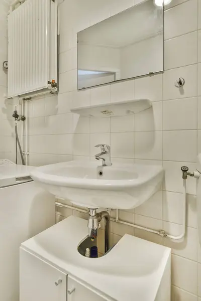 a bathroom with a sink, mirror and toilet paper dispensed on the wall next to the sink