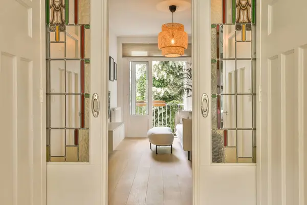 an entry way leading to the living room and dining area with mirrors on either side by side, as seen from the front door