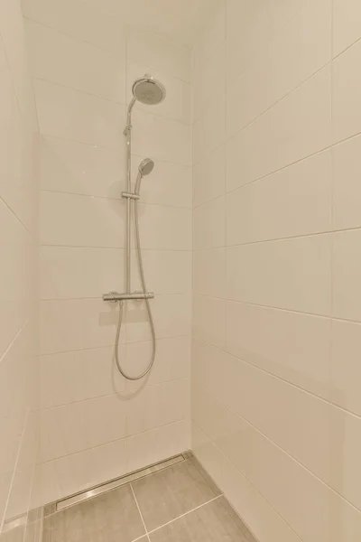 a shower with white tiles on the walls and tile floor in a bathroom area that is clean and ready for use