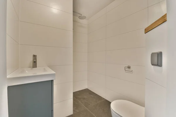 a bathroom with white tiles on the walls and gray tile around the shower stall, which has been used for several years