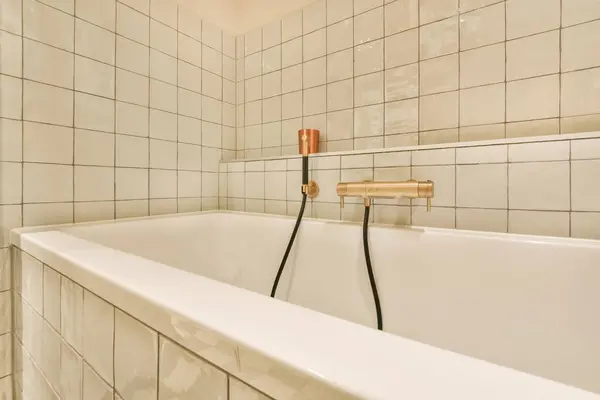 Uma Banheira Banheiro Com Azulejos Brancos Nas Paredes Uma Mangueira Imagens Royalty-Free