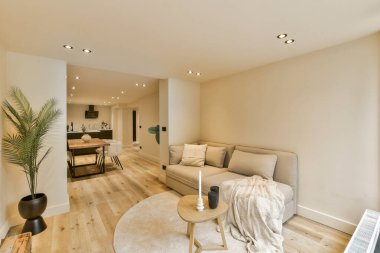 Oturma odası, kanepe, sehpa ve duvarın köşesindeki televizyon beyaza boyanmış.