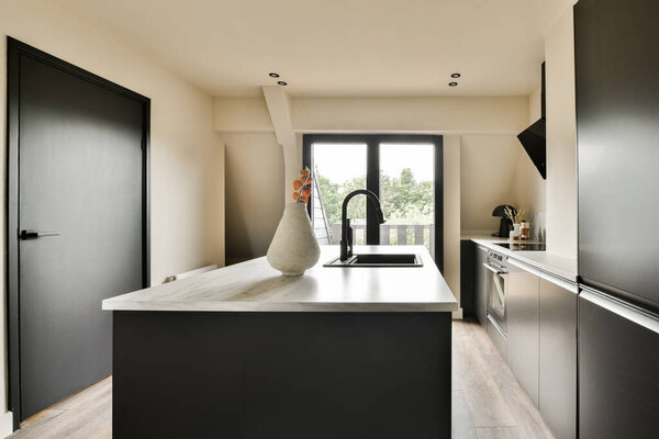 a modern kitchen with black cabinets and white counter tops in the center of the room is an open door that leads to a balcony