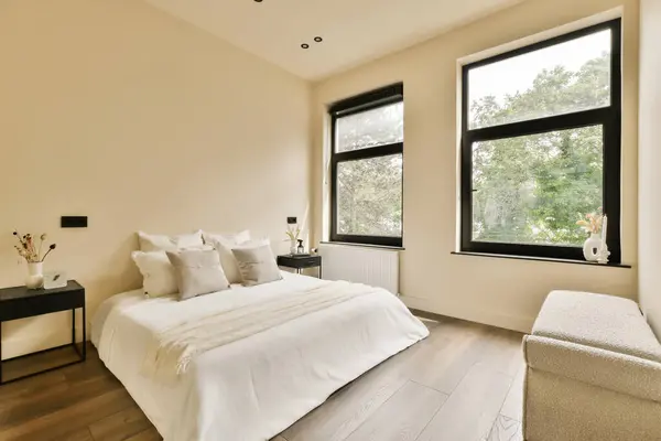 a bedroom with a bed, chair and window overlooking the trees in the distance is not visible on this photo