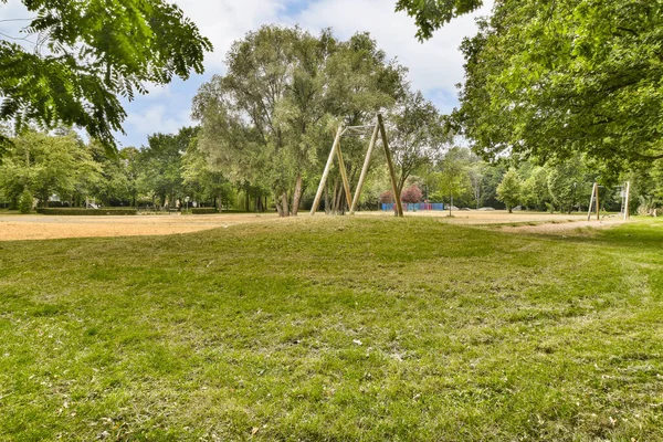 Önünde ağaçlar ve çimenler olan boş bir park. Görüntü Google Caddesi, Güney Londra stok fotoğrafından alındı.