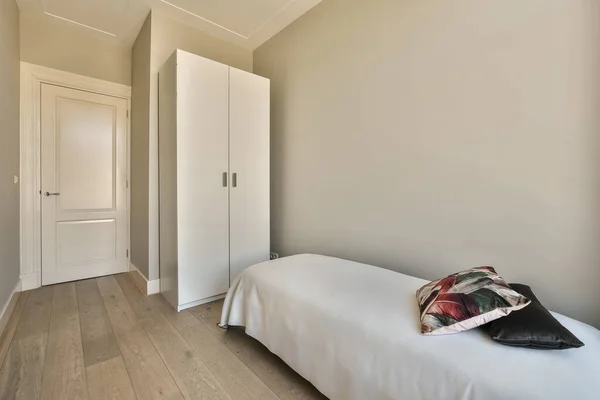 a bedroom with white walls and hardwood flooring the room is decorated in neutral tones, including light greys