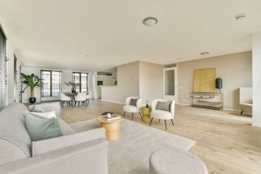 Minimalist mobilyaların, doğal ışığın ve modern renk paletinin yer aldığı geniş bir oturma odası, rahatlama ve sosyal toplantılar için mükemmel..