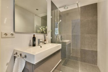 Minimalist tasarım elementleri, şık lavabo ve modern aksesuarlar, zarafet ve işlevsellik içeren gösterişli modern bir banyo..