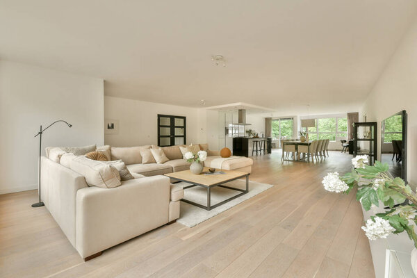 Spacious and beautifully designed living room featuring a light color palette, elegant furnishings, and ample natural light creating a serene atmosphere.