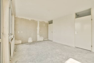 Boş, modern bir iç mekan çıplak duvarlar ve beton zemin, minimalist tasarım ve açık alan çok yönlülüğünün somut bir örneği..
