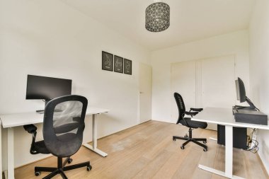 Hafif ahşap döşemeli, modern mobilyalı ve zarif ışıklandırmalı minimalist tasarımı olan çağdaş bir ofis. Sakinleştirici çalışma alanı için nötr bir palet kullanır.