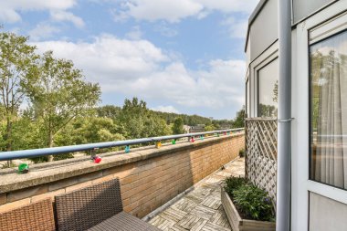Yeşillik ve açık gökyüzünün karışımından oluşan büyüleyici bir balkon sahnesi, açık havada mükemmel bir kaçış sağlıyor. Rahatlamak ve zevk almak için ideal güzellik..