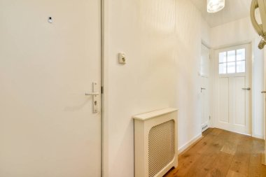 Bright and airy hallway featuring white walls and wooden flooring. The space is accented by modern light fixtures, creating a welcoming atmosphere. clipart