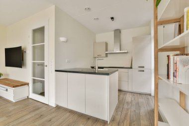 Gösterişli dolaplar, ahşap döşemeler ve minimalist estetikle donatılmış modern mutfak. Parlak ve işlevsel alan aşçılık yaratıcılığını davet ediyor.