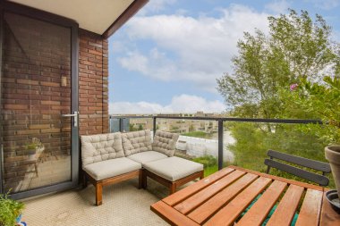 Rahatlatıcı bir balkon sahnesi şık dış mobilyalar, bitkiler ve bulutlu bir gökyüzünün altında manzaralı bir manzara, boş zamanların tadını çıkarmak için mükemmel..