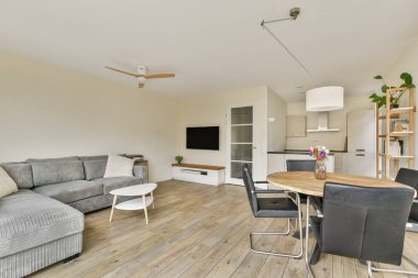 Rahat bir kanepe, yemek masası ve hoş bir dekorun bulunduğu şık ve çağdaş bir oturma odası..