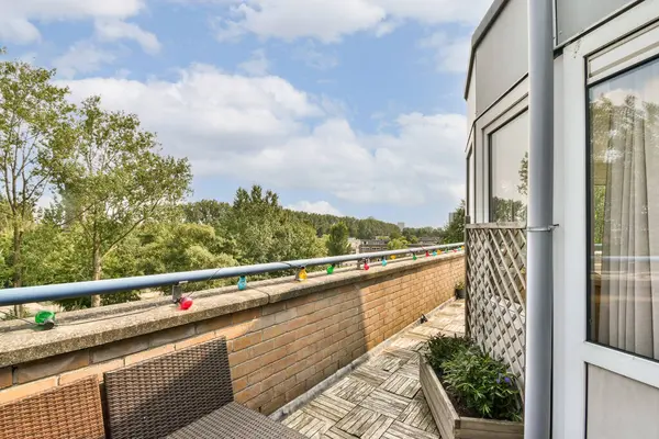 Yeşillik ve açık gökyüzünün karışımından oluşan büyüleyici bir balkon sahnesi, açık havada mükemmel bir kaçış sağlıyor. Rahatlamak ve zevk almak için ideal güzellik..