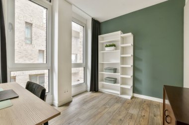 Bu resim, büyük pencereler ve temiz çizgilerle doğal ışık ve konforu artıran minimalist estetik bir iç mekan sergiliyor..