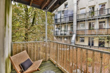 Kırsal mobilyaların ve yeşilliklerin yer aldığı güzel tasarlanmış bir balkon, şehir ortamında rahatlamak ve manzaranın keyfini çıkarmak için mükemmel..