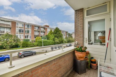 Sakin bir balkon, kentsel daireleri ve yemyeşil alanları gösteriyor. Şehirdeki günlük hayatın tadını çıkarmak ya da gevşemek için ideal..